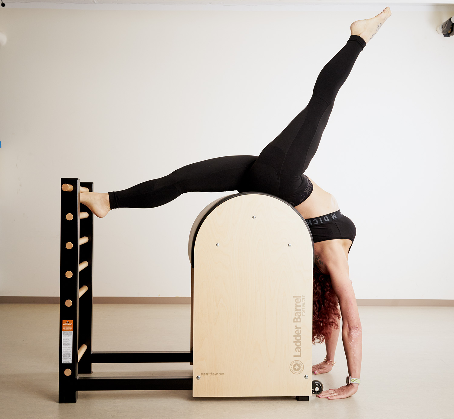Mujer haciendo el pino en una máquina de pilates